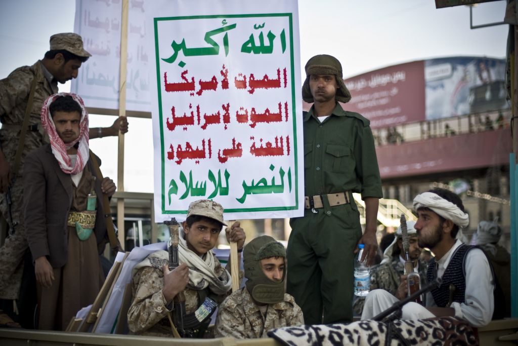 Houthi Shiite fighters wearing army uniforms ride on a pickup truck as they guard a street during a demonstration in Sanaa, Yemen, January 23, 2015. Their sign reads 'death to Israel, cursed be the Jews' (photo credit: AP/Hani Mohammed)